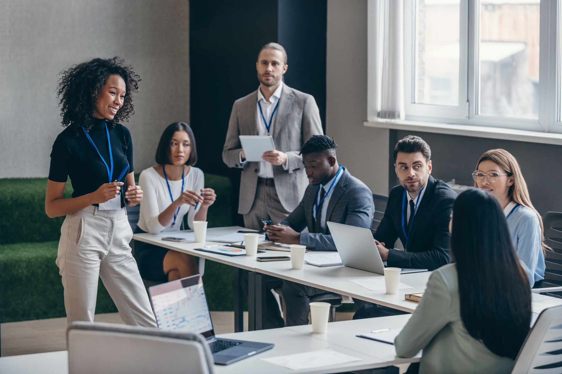 Smiling African female speaker talking to audience during a business conference in convention center